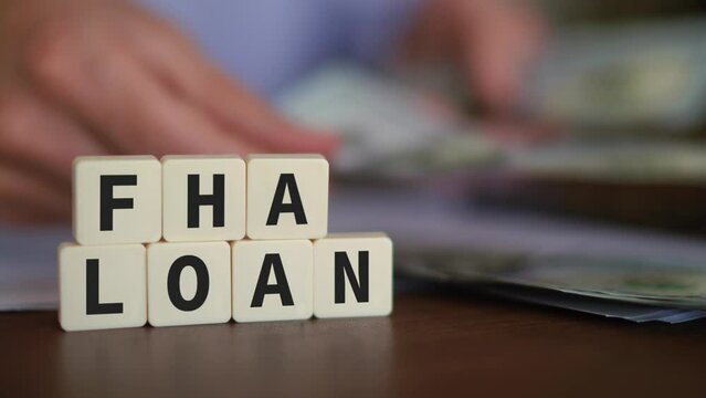 Concept of FHA Loan. Person receiving Federal Housing Administration loan in the U.S. Selective focus with money on the background.