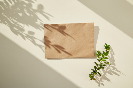 Craft paper envelope mock up under sunny shadows. Copy space