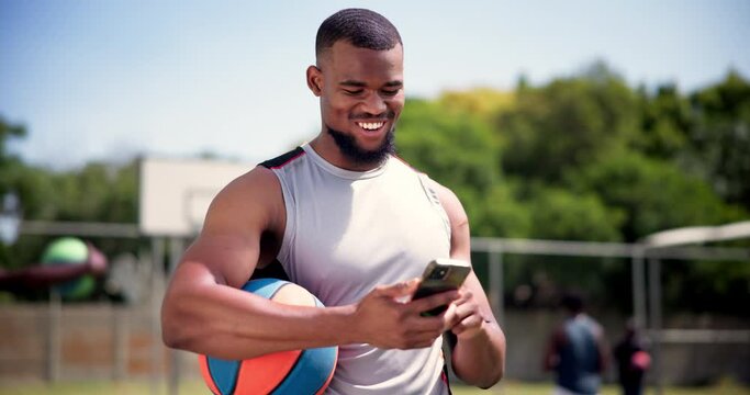 Athlete, cellphone and basketball on court with happiness, technology and text message or social media . Black man, laughing and smartphone for streaming online and funny sport videos on mobile app