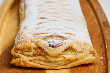 Strudel with sweet cheese and raisins with powdered sugar sprinkled on top, produced at home.