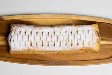 Strudel with sweet cheese and raisins with powdered sugar sprinkled on top, produced at home.