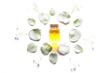Spa and wellness concept. Essential massage oil on white background with flowers and eucalyptus...