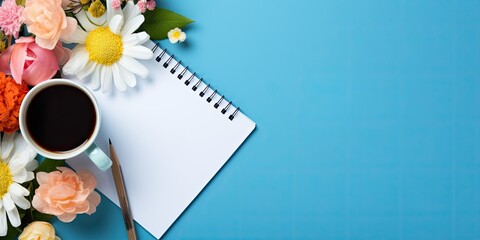 Colorful office supplies with a white notepad, cup, pen, computer, crumpled paper, and flower on a blue background.