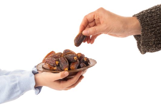 Girl child holding offering serving plate of date fruits for her mother. Woman taking one of the date fruits to break her fast for Iftar hour. Isolated transparent png background.