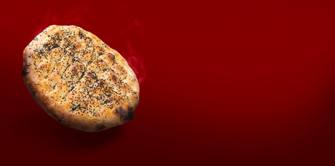Ramadan pide, fresh baked piping hot traditional Turkish cuisine pastry Ramadan pide. Dark red background, copy space. Black cumin, sesame seeds, eggy halal healthy pastry. Food for Iftar.