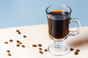 Clear glass filled with coffee with grains.