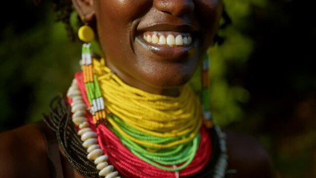 African Woman Wears Colorful Beaded Necklaces And Earrings. - close up