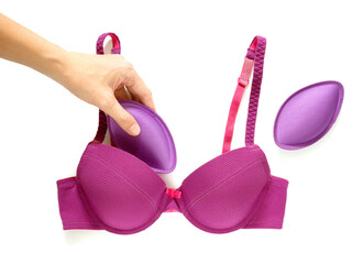 Hand inserting bra pad into brassiere © Saranya