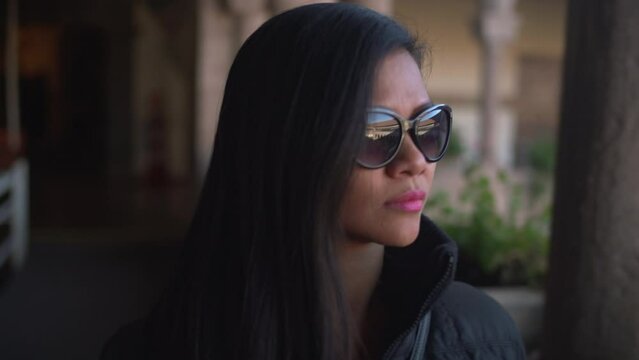 Asian woman with sunglasses during winter appreciating the view of the Qorikancha sacred temple in Cusco Peru.