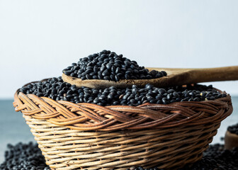 Obraz premium Beluga lentils in a wooden spoon on a bowl macro view 
