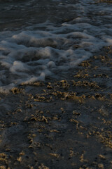 Sea wave reaching the stones of the shore