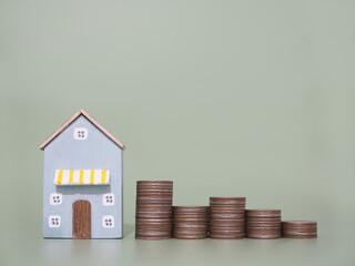 Miniature house and stack of coins. The concept of saving money for house, Property investment, House mortgage, Real estate.