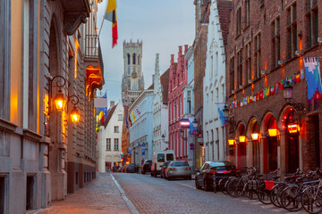 Scenic cityscape with medieval fairytale town, street and tower Belfort at night, Bruges, Belgium