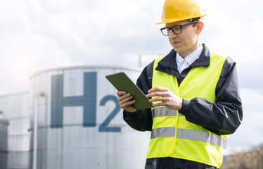 Engineer with tablet computer on a background of Hydrogen factory