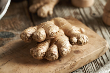 Fresh ginger root on a wooden cutting board, close up