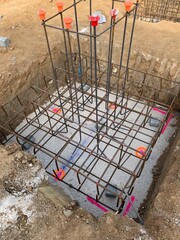 Reinforcement of an isolated footing in a construction site. Foundation ready to pour concrete, with all the rebars assembled. Grid of rods for a new structure.