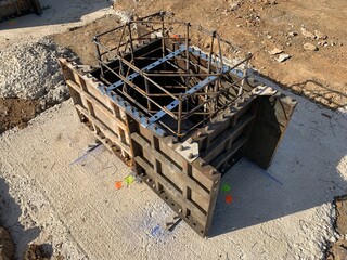 Close up shot of a formwork to build a foundation column. Metallic framework with reinforcement inside ready to pour concrete. Detail shot of the structure process in construction.