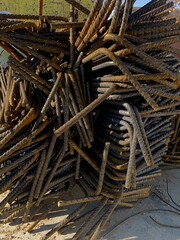 Pile of rebars for foundation reinforcement. L shape reinforcement steel rod. Construction metallic bars on the ground ready to assemble.