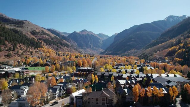 Low to high pullback drone shot revealing the city of Telluride, CO