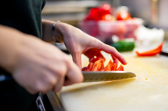 Chef hand cut tomatoes on a chopping board