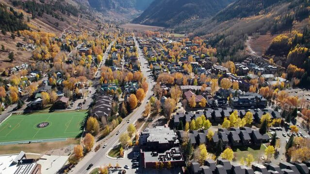 Orbiting drone shot of downtown telluride, CO on a sunny day with fall colors
