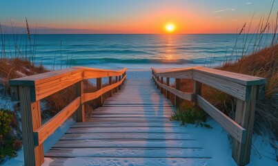 Fototapeta premium Long boardwalk leading to white sand beach and ocean at sunset