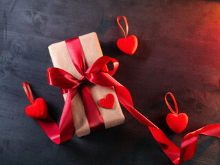 Gift box in craft paper with red ribbon, red hearts. Valentine's Day gift top view