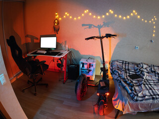 Hipster room. a workplace with a computer. electric scooter and monocycle. neon light