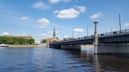 A majestic bridge spans over the glistening water, while a grand clock tower stands tall in the background.