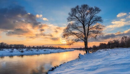 Fototapeta na wymiar lonely tree on the bank of a winter river with snow covered banks and an evening sky with a beautiful sunset