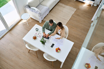 Mature couple calculating taxes finances, money savings, paying bills online at home. Middle aged...