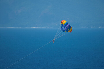 Single person paragliding from boat at beau vallon beach, Mahe, Seychelles  - obrazy, fototapety, plakaty