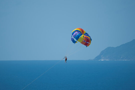 Single person paragliding from boat at beau vallon beach, Mahe, Seychelles 