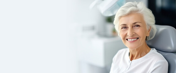 Cute elderly gray-haired woman smiling with white teeth, sitting in dental chair in the clinic. Concept of dental treatment, health, consultation with an orthodontist, stomatology, medical care Banner
