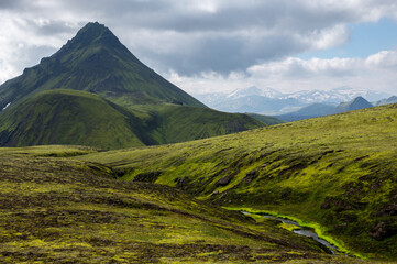 Fototapeta premium Amazing Icelandic landscape with mountains, river and field on a sunny day at famous Laugavegur hiking trail, South Iceland. Acid colours landscape.