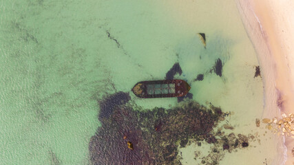 Aerial view of a sunken boat. Sunken ship at shallow depth, near the beach