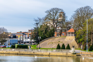 A view across the River Great Ouse towards the Castle Hill in Bedford, UK on a bright sunny day