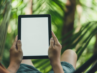 Mockup close-up of a person's hands holding a tablet with a white blank screen