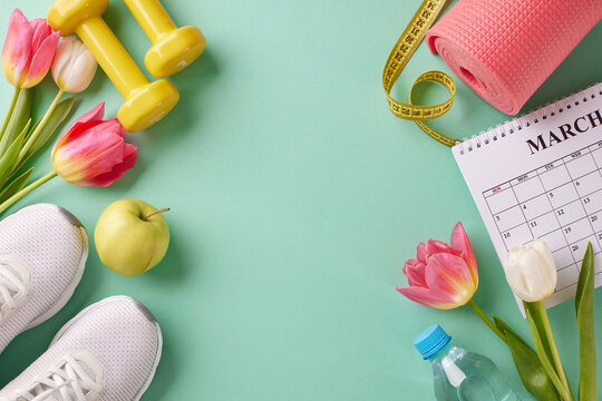 Elevate your energy: mapping out your dynamic spring workout plan. Top view photo of calendar, apple, white sneakers, water bottle, sport equipment, flowers on turquoise background with advert area