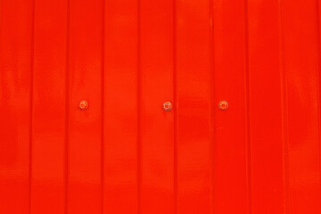 Red metal surface with spots creating textured wall background
