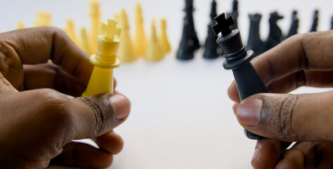 Close up of a man playing chess with the black king on the white background