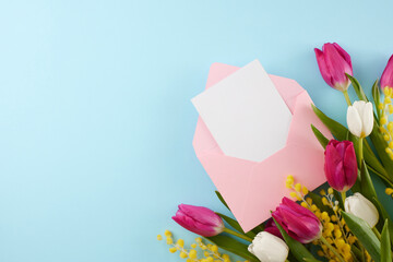 Feminine radiance revelry: a celebration of women's empowerment. Top view photo of pink envelope with card, fresh tulips, mimosa on pastel blue background with space for advert or festive text