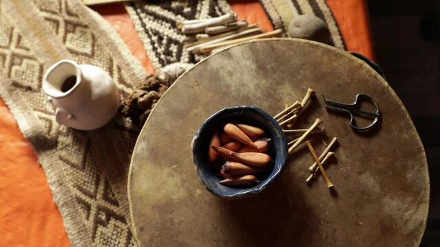 Mapuche culture and tradition. Closeup view of Mapuches musical instruments. A Trompe and mapuche sacred fruits called pi&radic;&plusmn;ones, from Araucaria tree, laying over a a drum called Kultrun.