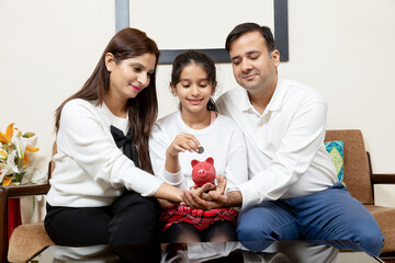 Indian latin family putting coins in jar saving fir future plans,Saving or mutual fund concept