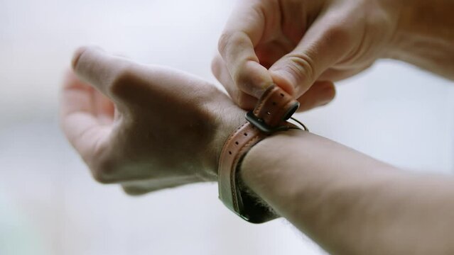 Man's accessories and dressing . Smart watch . Man fastens watch on wrist	