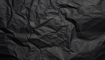 Heavy crumpled black paper texture in low light background