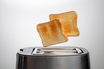 Modern toaster with bread slices on white background
