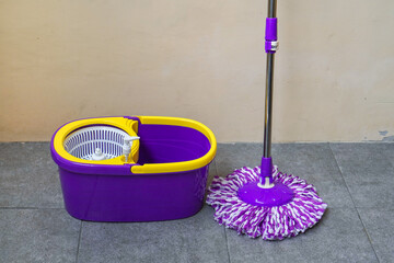 a modern floor mop propped against the wall.