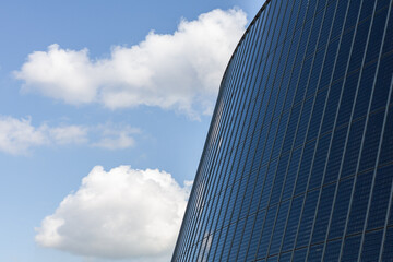 Modern office building with blue sky and white clouds. Business background.