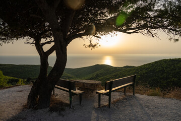 Bench with the view on sunset. Mediterranean sunset from the Agalas viewpoint. Sitting and watching...